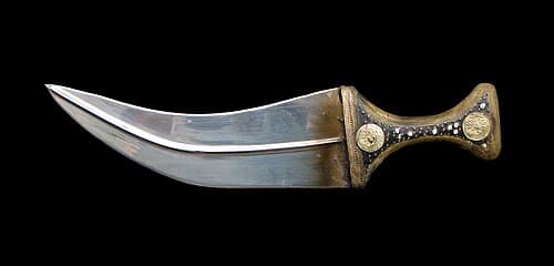 Traditional Yemeni jambiya dagger charm with curved blade and ornate handle in decorative sheath