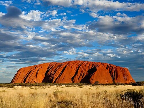 Small polished red sandstone charm shaped to evoke the iconic silhouette of Uluru