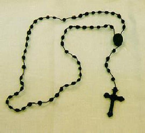 A classic black obsidian rosary with a silver crucifix, each bead polished to a deep luster