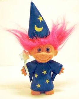 A classic troll doll with wild fluorescent pink hair, wide eyes, and a broad grin, seated with hands on belly
